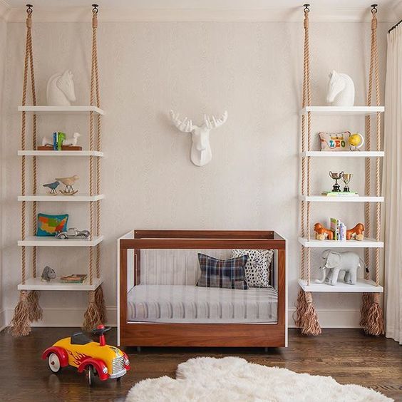 shelving units hanging on ropes with tassels on both sides of the crib is a cool idea that brings a relaxed feel to the space