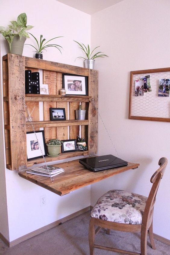 a DIY rustic Murphy desk made of a stainned pallet and chains that hold the desktop in a very secure way and with display space