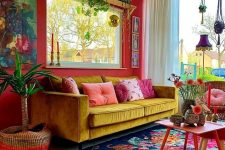 a bold mid-century modern space with a red accent wall, a yellow sofa, a colorful floral rug, lots of potted plats and a vintage chandelier