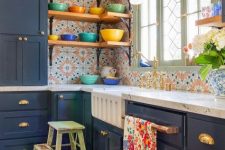 a bright maximalist kitchen with navy cabinets, bright printed tiles, a bold rug and textiles and colorful dishes