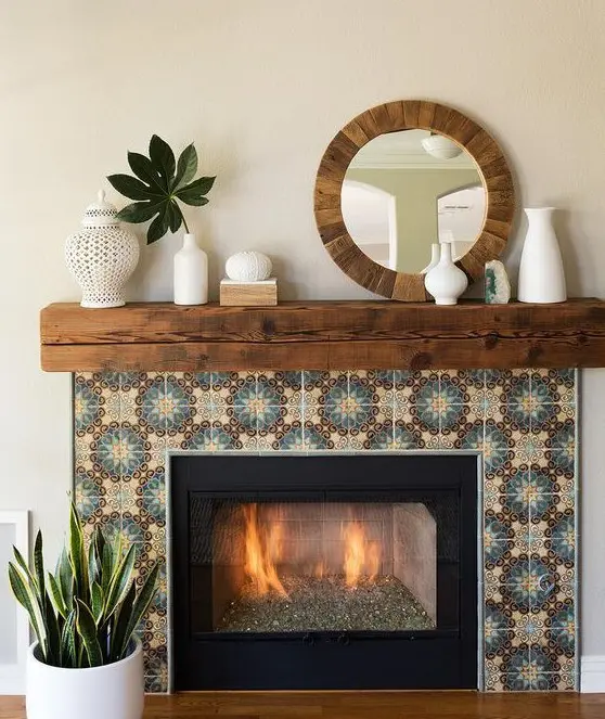 A built in fireplace clad with colored patterned tiles around, with a rich stained wooden slab mantel