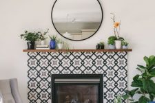 a built-in fireplace surrounded with black and white geometric tiles and with a stained wooden mantel with plants in pots