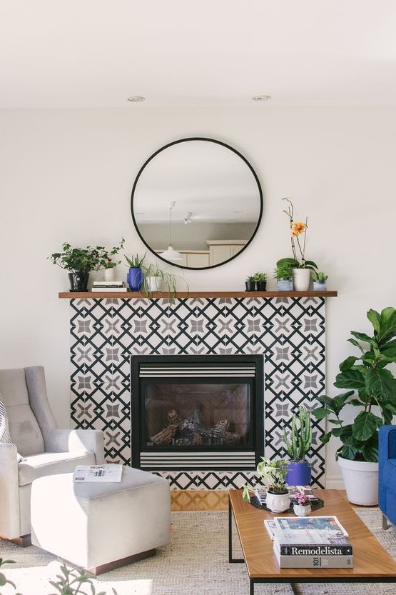 A built in fireplace surrounded with black and white geometric tiles and with a stained wooden mantel with plants in pots