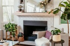 a built-in fireplace with grey and white patterned tiles around and up to the ceiling and a simple wooden mantel