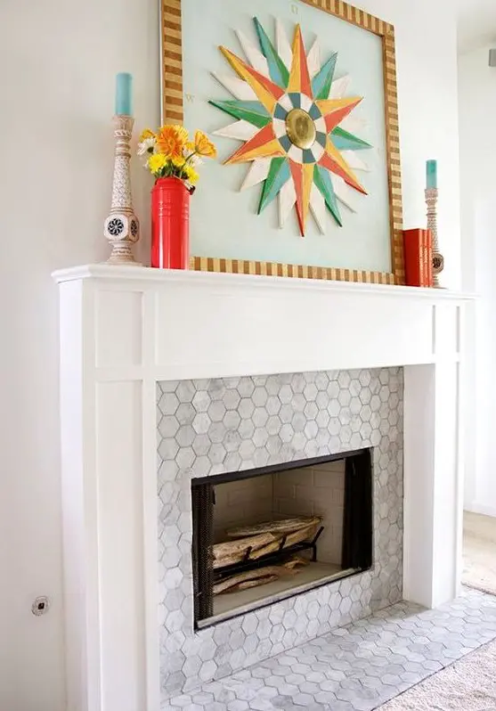 A built in fireplace with marble hex tiles around it and on the floor and a stylish white frame and mantel