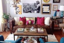 a colorful eclectic living area with a crazy gallery wall, velvet and leather furniture, an industrial coffee table