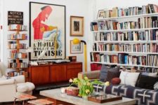 a colorful eclectic living room with open bookshelvesm bright printed textiles, neutral furniture and touches of mid-century modern