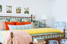 a colorful eclectic sleeping space with a bamboo bed, a gallery wall with holiday photos, elegant blue and white side tables and a bead chandelier