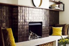 a fireplace done with metal tiles, with a firewood storage space and a concrete bench with bold pillows
