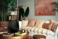 a moody eclectic space with a statement artwork, a boho printed rug, lots of earthy pillows and metal hammered items