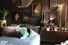 a moody eclectic space with dark walls, a vintage-inspired gallery wall, bold bedding and accessories