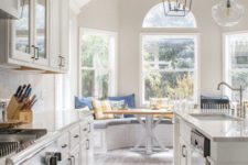 a neutral farmhouse galleykitchen with chic cabinets and white stone countertops, a wooden floor and catchy pendant lamps