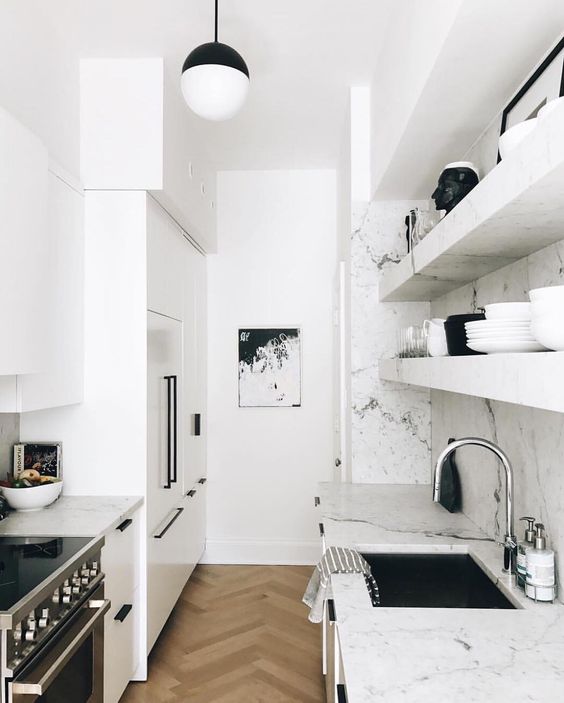 a small white Scandinavian kitchen with white marble countertops and backsplash plus black touches