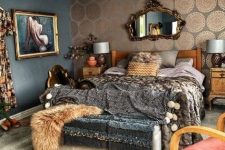 a sophisticated maximalist bedroom with an accent printed wall, wooden furniture, dark printed textiles, a vintage mirror and a crystal chandelier