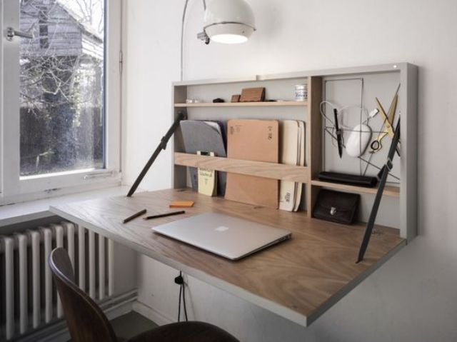 a stylish modern Murphy desk with a grey base and a stained plywood desktop plus some minimal storage space inside
