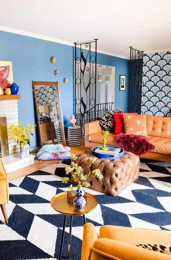 A super colorful eclectic living room with jewel tones, several prints, catchy gold touches and a sleek TV unit.