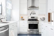 a tranquil neutral galley kitchen with white cabinets and countertops, a navy floor and stainless steel appliances