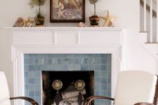 a vintage fireplace with a blue Zellige tile surround and a white mantel is a stylish and chic coastal space idea