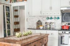 a white traditional kitchen with dark countertops spruced up with a vintage wodoen kitchen island to make it more relaxed