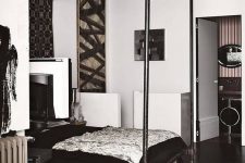 an eclectic bedroom with a frame bed, black and white bedding, some artwork, a bold rug, a basket is amazing
