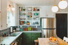 an eclectic kitchen with green and white cabinets, a printed tile backsplash and white countertops, a farmhouse kitchen island