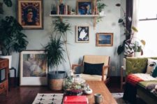 an eclectic living room with a gallery wall, open shelves, light blue walls, vintage furniture and potted greenery