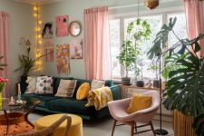 an eclectic living room with mint walls, a dark green sofa, a pink chair, a yellow ottoman, a bright gallery wall and lights