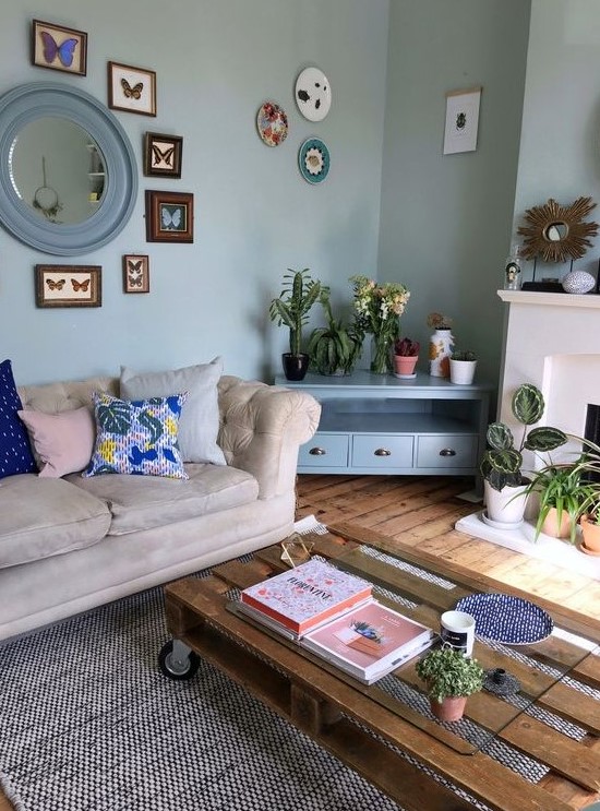 an eclectic space with a pallet coffee table, a neutral sofa unified with light blues and aqua shades