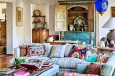 an ethnic maximalist living room with pastel blue seating furniture, a turquoise buffet, a Moroccan lamp and bold ethnic textiles