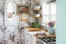 traditional white cabinets with butcherblock countertops are combined with a floral wall, a glam lamp and a boho rug
