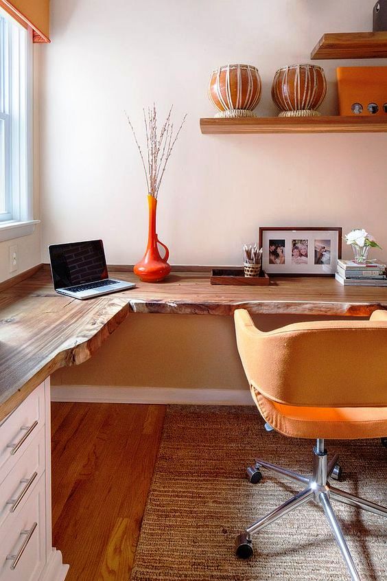 A live edge corner wooden desk with white drawers and mustard touches for a stylish mid century modern home office