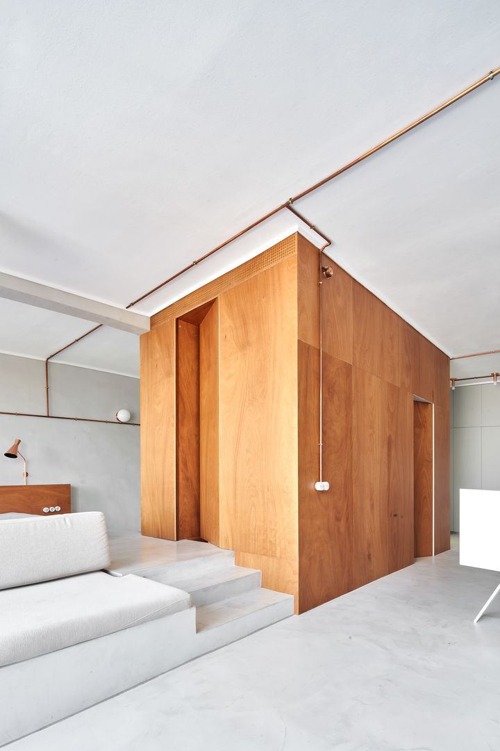 The plywood unit contains toilets, closets and laundry and divides the spaces