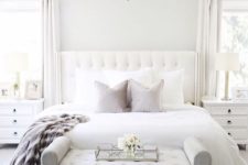 03 a chic bedroom in neutrals, with white walls, a white upholstered bed and a grey upholstered bench