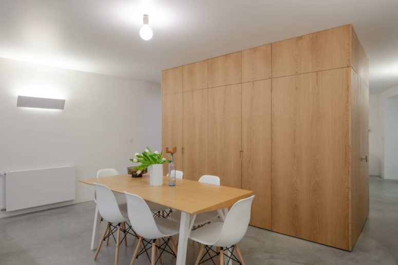 The spaces are divided with a large storage unit of light-colroed plywood