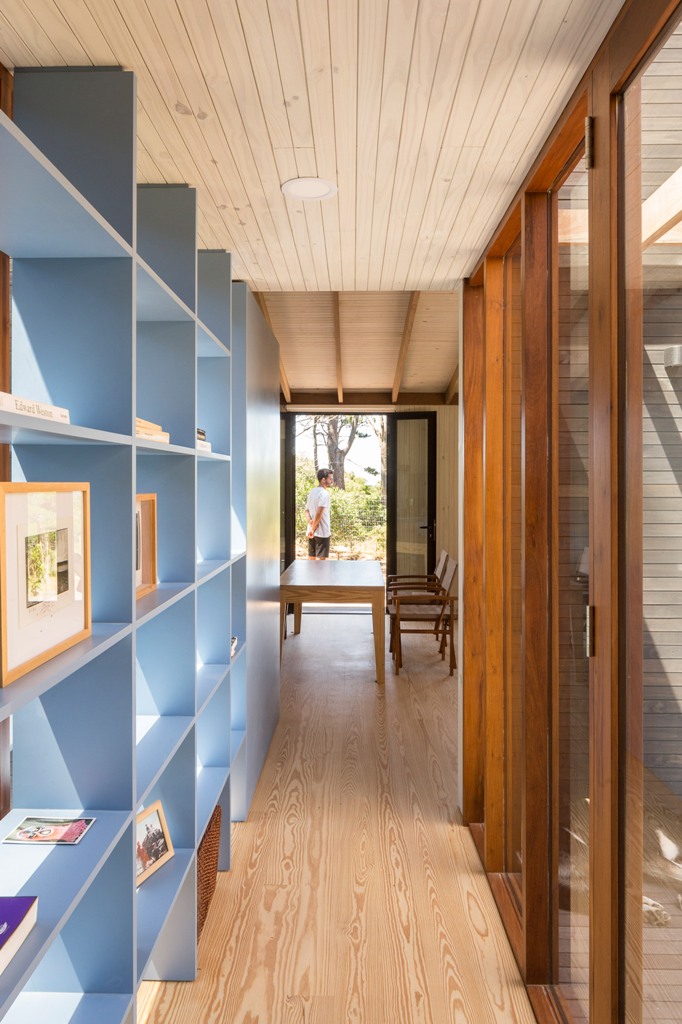 A blue bookshelf is a storage unit and a space divider at the same time