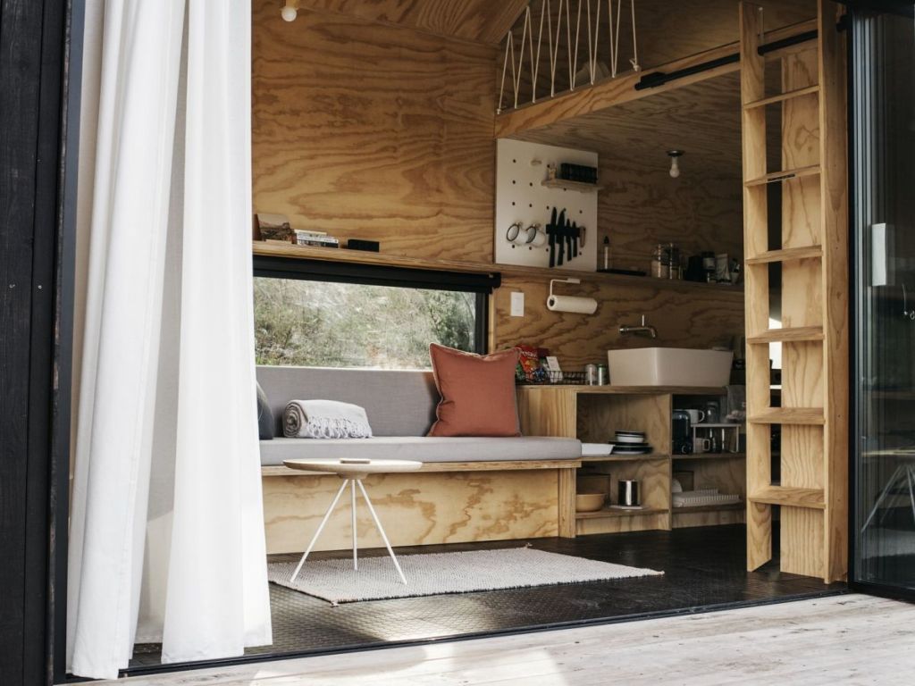 The furniture is minimalist and built in, it's very functional, and the cabin itself is very small to inspire to spend more time outdoors