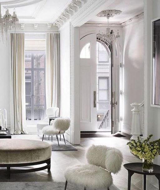 a neutral Parisian living room in white and beige, with high ceilings and large windows is classics