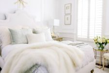 05 a neutral glam bedroom with white walls, a statement crystal chandelier and chic bedding plus faux fur