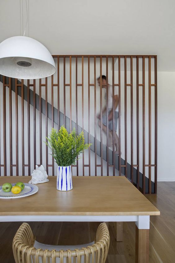 a sleek contemporary wooden screen perfectly finishes the space and separates the staircase from the rest of the home