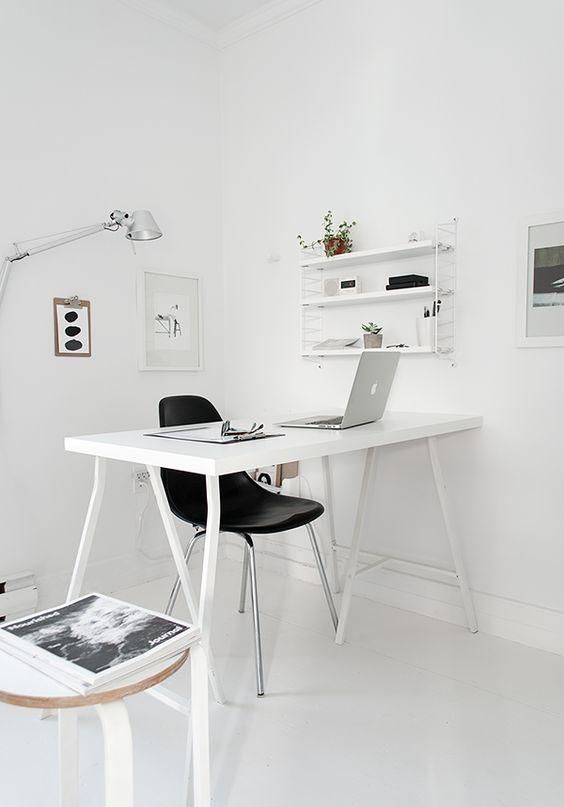 a stylish Nordic home office in white, with a sleek desk, some shelves and negative space
