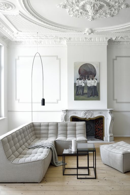 an all-white living room with a light grey sofa and some touches of black for a bit of drama
