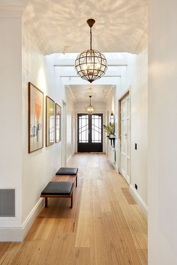 Large mid century modern framed glass pendant lamps bring so much light that two are enough for the whole hallway