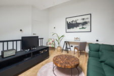 07 The living room is combined with a home office, there’s a statement green sofa, a blush rug, a catchy table and a TV