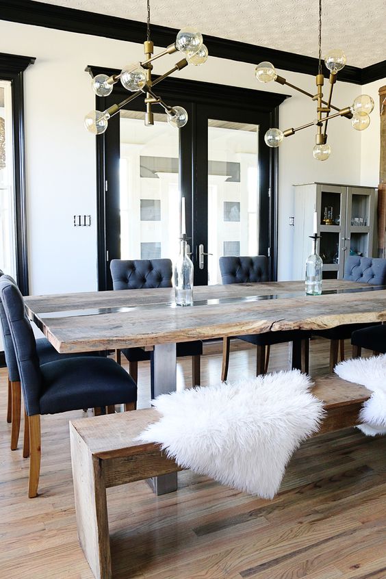 a live edge dining table and a matching reclaimed wood bench contrast the chic blue chairs