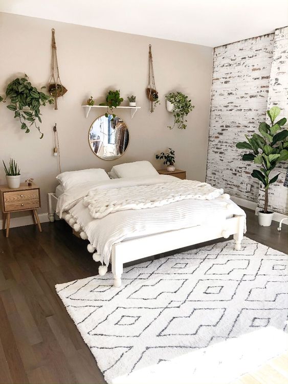 a neutral boho minimalist bedroom in white and greys plus light-toned wooden furniture