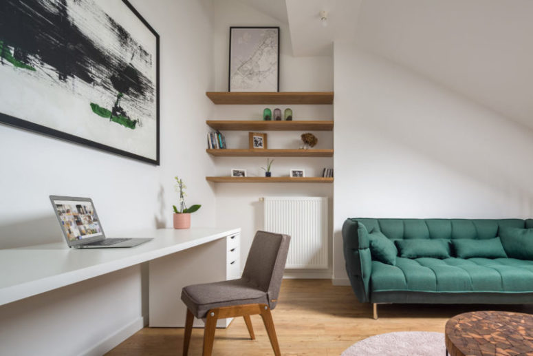 The home office space features a large white desk, a grey chair and some open shelves taking an awkward corner