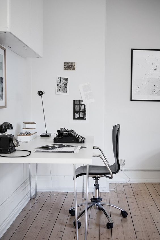a contemporary white home office with touches of black and vintage items to give it a character