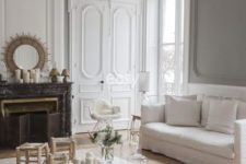 08 a neutral Parisian living room with light-colored wood parquet floors that are covered with striped rugs