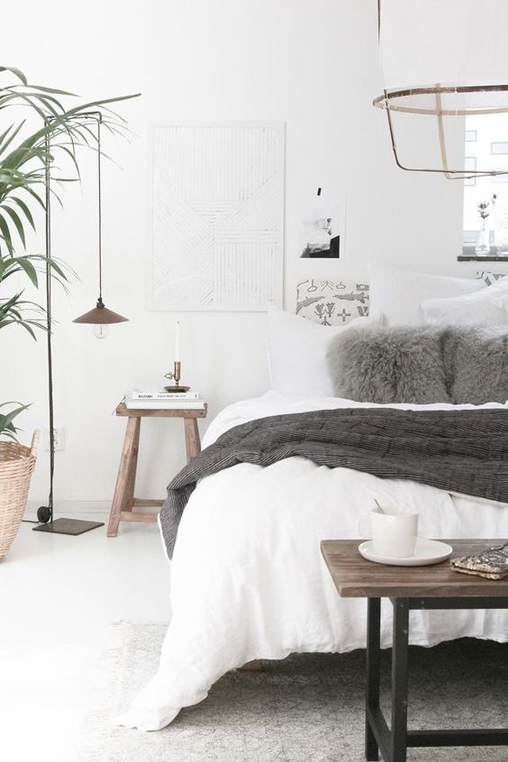 a neutral Scandinavian bedroom with grey accent touches and dark stained wooden furniture