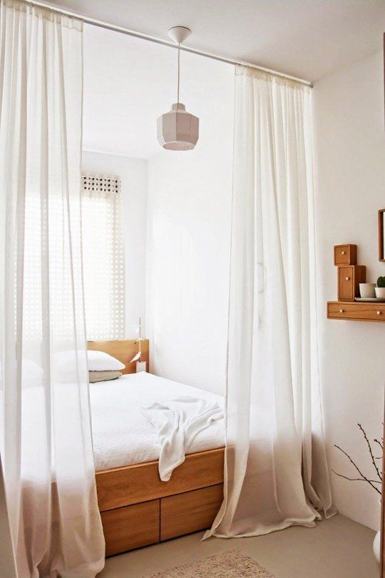 a sheer white curtain is a perfect option to separate a sleeping space from the rest of your apartment